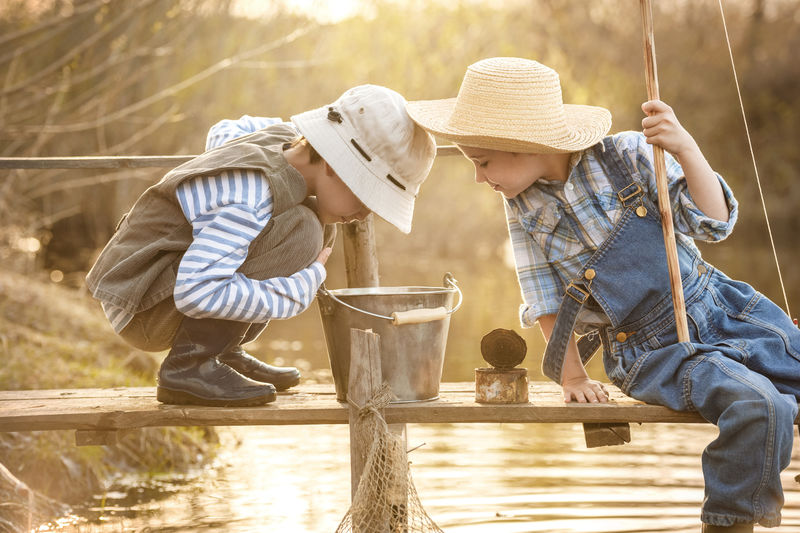 小男孩日落时在湖边钓鱼
