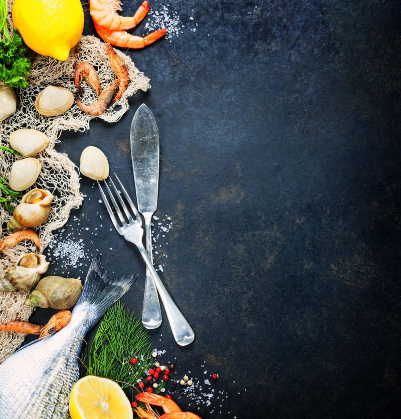 美味的新鲜鱼类和海鲜在深色葡萄酒的背景-鱼、蛤蜊和虾配芳香草本、香料和蔬菜-健康食品、饮食或烹饪概念
