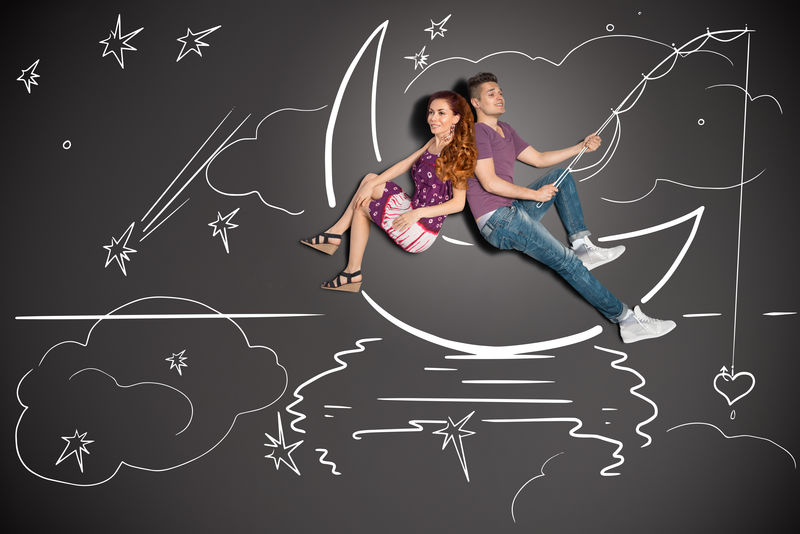 快乐的情人节爱情故事的概念是一对浪漫的情侣在月亮上钓鱼-心形挂在粉笔画的背景上
