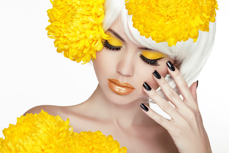 美丽的金发女性肖像-有黄色的花-美丽的水疗女抚摸着她的脸-化妆和修剪指甲-完美的新鲜皮肤-白底隔离