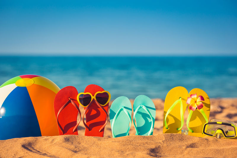 沙滩上的人字拖、沙滩球和浮潜-暑假概念