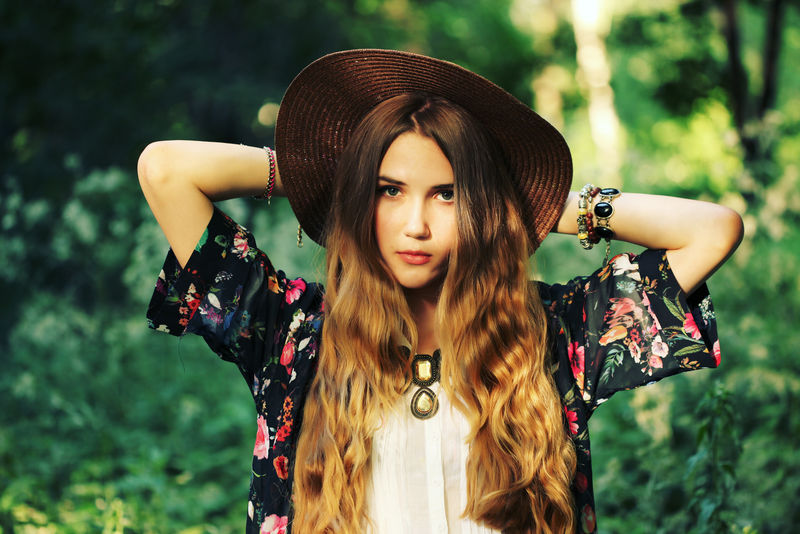 美丽的嬉皮士年轻女子的时尚肖像-穿着波西米亚时尚的衣服-戴着夏季的户外帽子-柔软温暖的复古色调-艺术的波西米亚风格