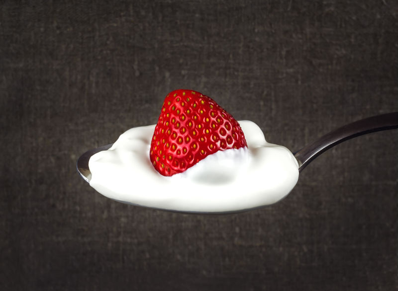白奶油草莓放在银勺上。