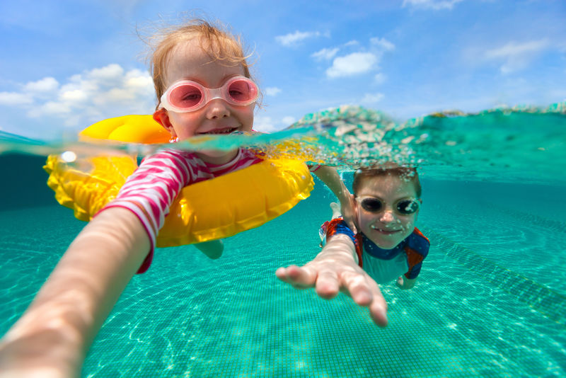 上面的水下照片和可爱的孩子们在暑假快乐游泳