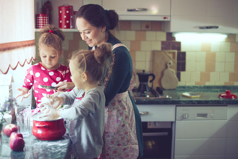 母亲带着她5岁的孩子在厨房里做节日派到母亲节-在现实生活的室内休闲生活照片系列