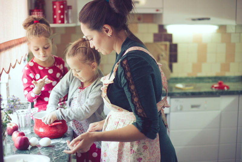母亲带着5岁的孩子在厨房里做节日派-现实生活中的休闲生活照片系列
