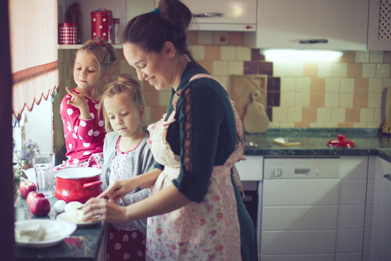 母亲带着她5岁的孩子在厨房里做节日派到母亲节-在现实生活的室内休闲生活照片系列