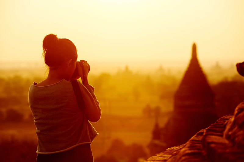 日出时巴冈缅甸亚洲女游客摄影寺庙