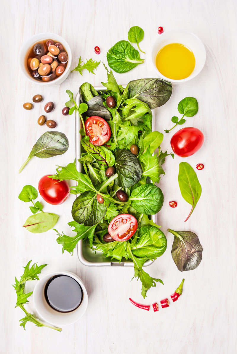 野菜沙拉-番茄、橄榄、油和醋-白色木质背景-俯视图