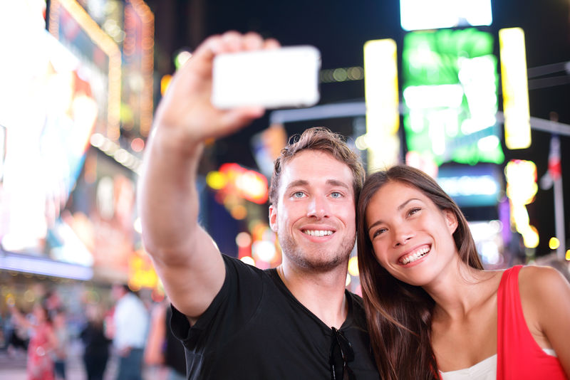 晚上在纽约时代广场拍自拍自拍照片-美丽的年轻游客-有乐趣的约会-曼哈顿-美国-亚洲女人-高加索男人
