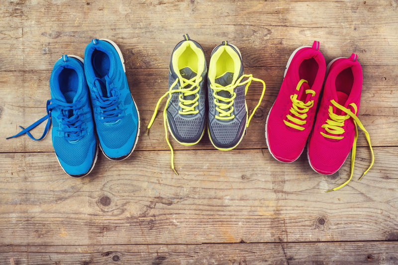 木地板背景上各种颜色的运动鞋