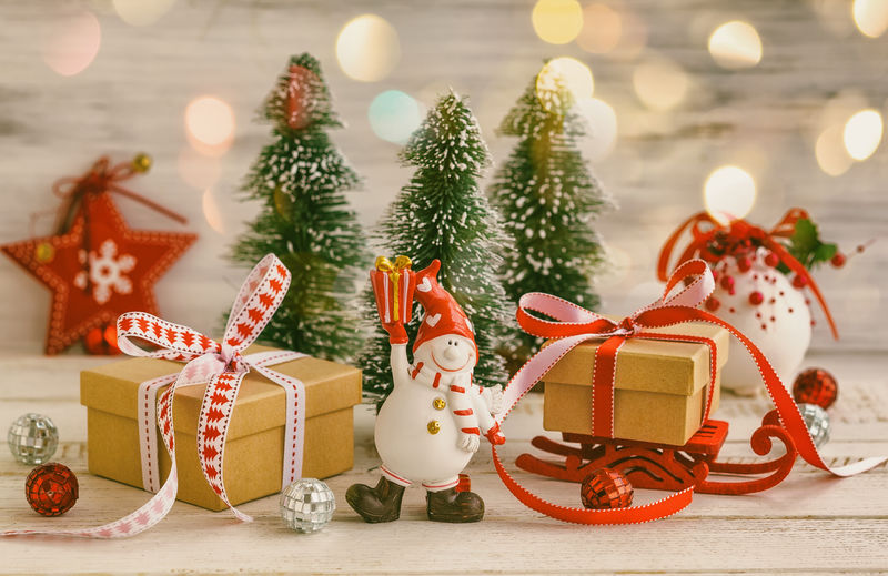 雪人、礼品盒和白色木质背景的装饰圣诞树-复古风格