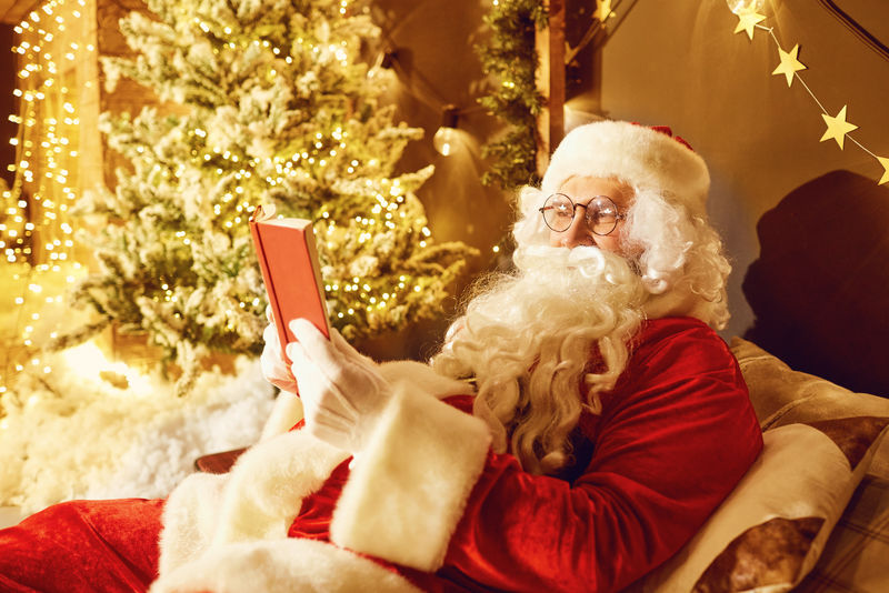 圣诞老人在一间有壁炉的房间里看书
