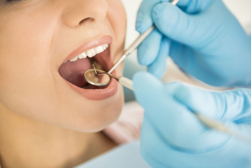 牙医在牙科检查病人的牙齿
