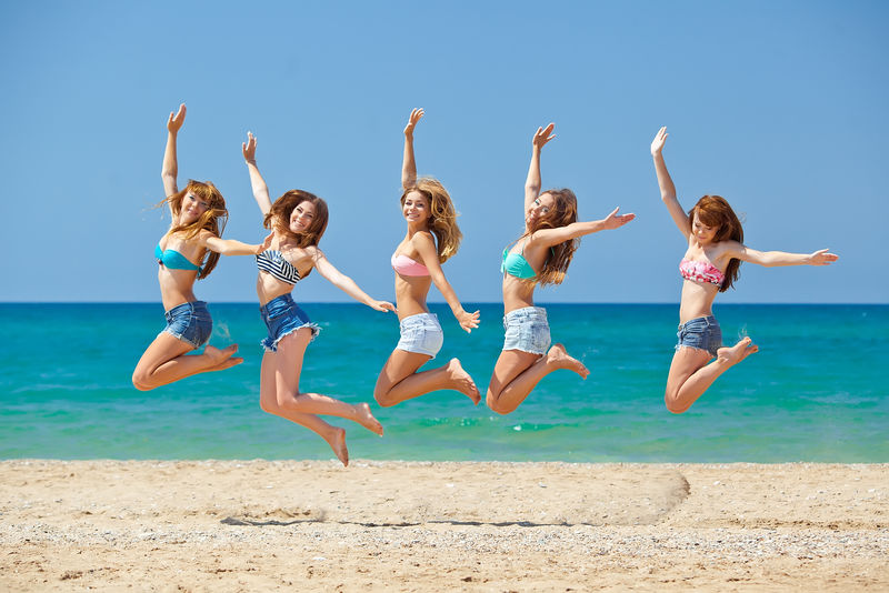 夏天-假期-假期-快乐的人的概念-一群朋友在海滩上跳跃和奔跑