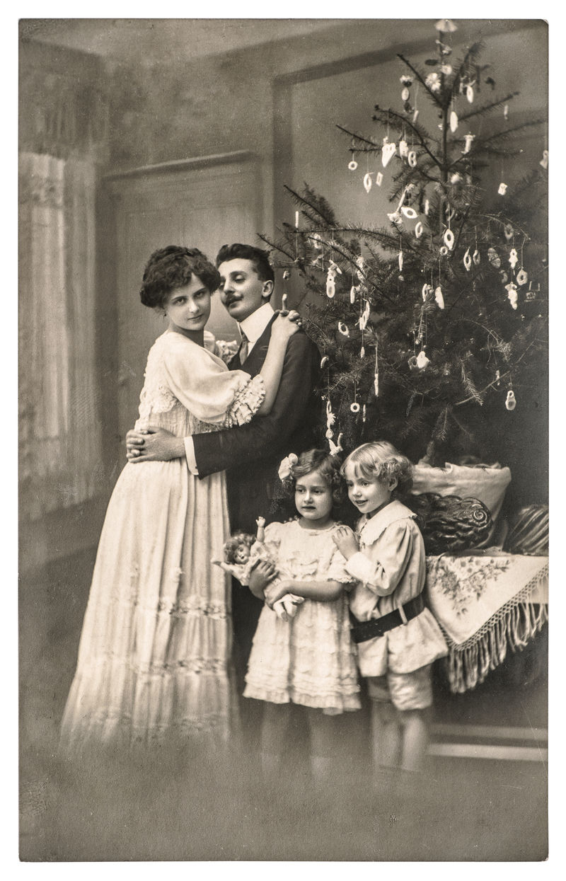 维多利亚家庭的父母和孩子都有圣诞树-带原始胶片纹理和模糊的复古图片