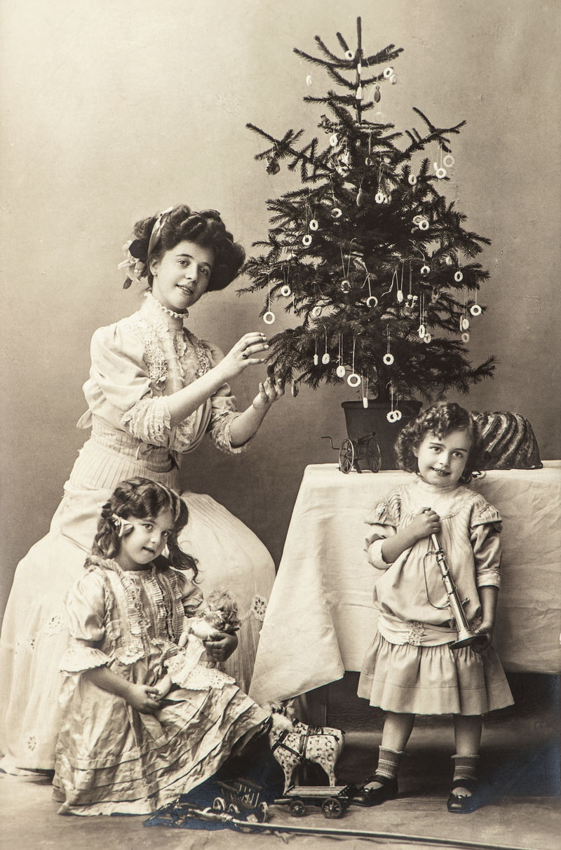 带着圣诞树和古董玩具的快乐母亲和孩子们-带原始胶片纹理和划痕的复古深褐色图片