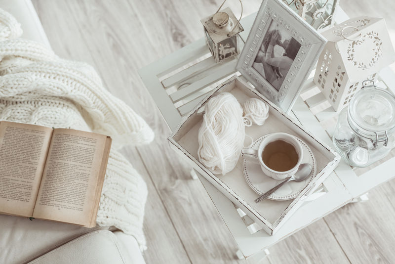 静物细节-一杯茶在复古葡萄酒木制托盘上的咖啡桌在客厅-顶视图-慵懒的寒假周末带着一本书在沙发上