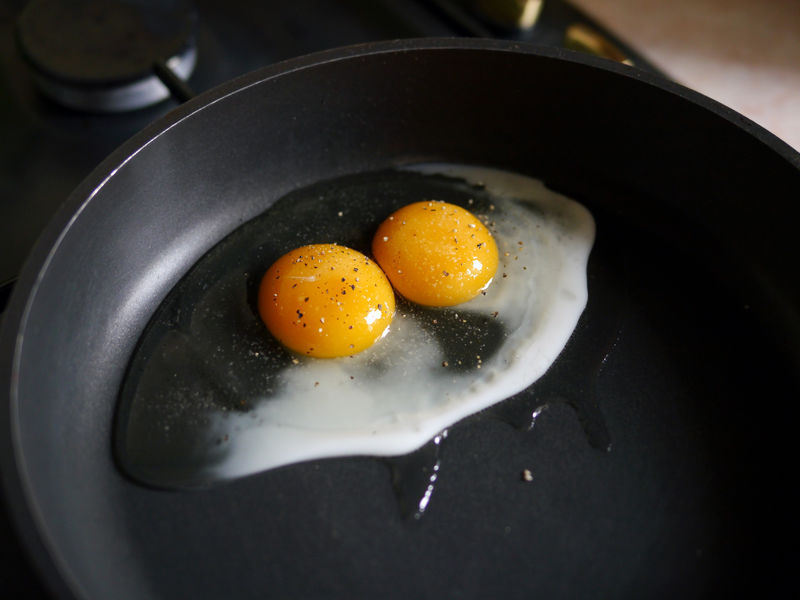 炒蛋-平底锅里的两个蛋黄-简单的早餐和晚餐