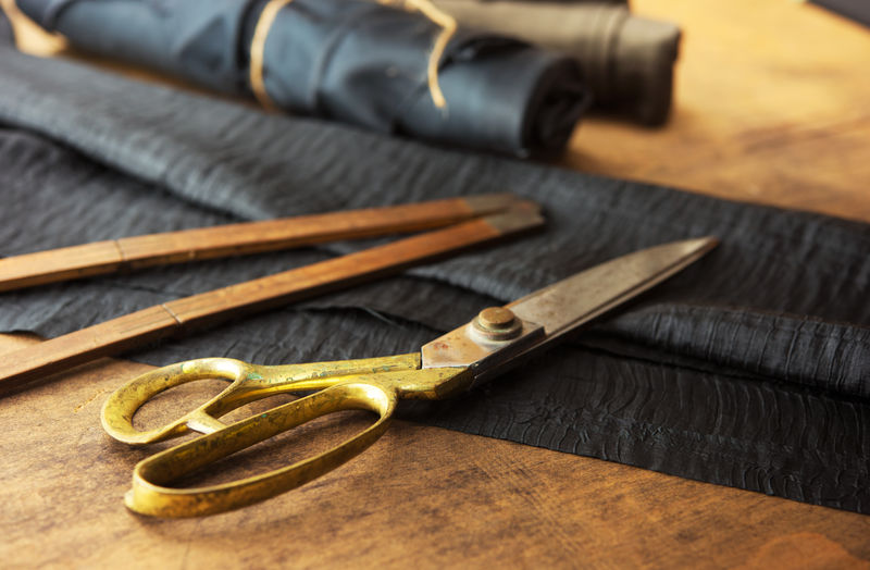 测量和切割织物或细布-裁缝的工作台-金剪刀和黑色织物