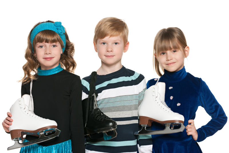 三个带着白色背景的溜冰鞋微笑的孩子