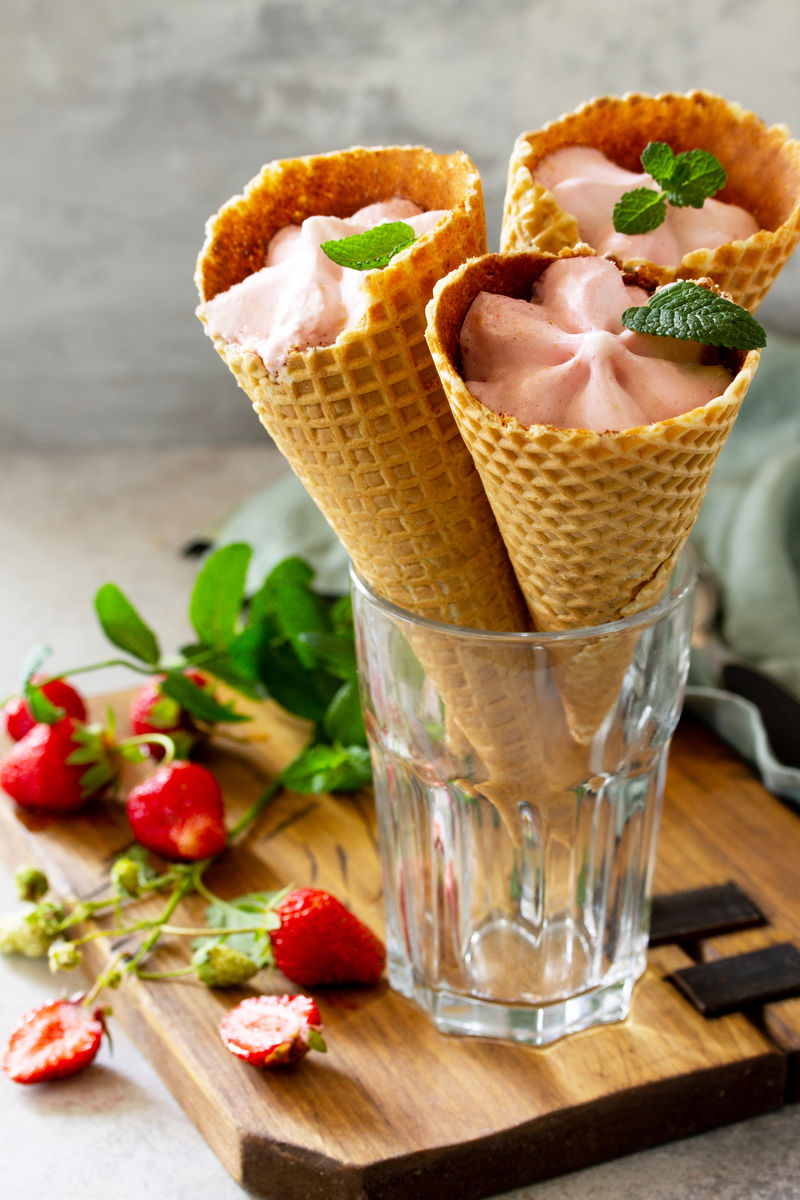 草莓冰淇淋舀成圆锥形放在轻石桌或石板桌上。