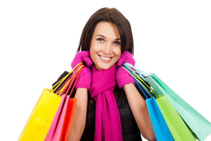 冬天购物的女人开心地微笑着拿着白色背景隔离的袋子