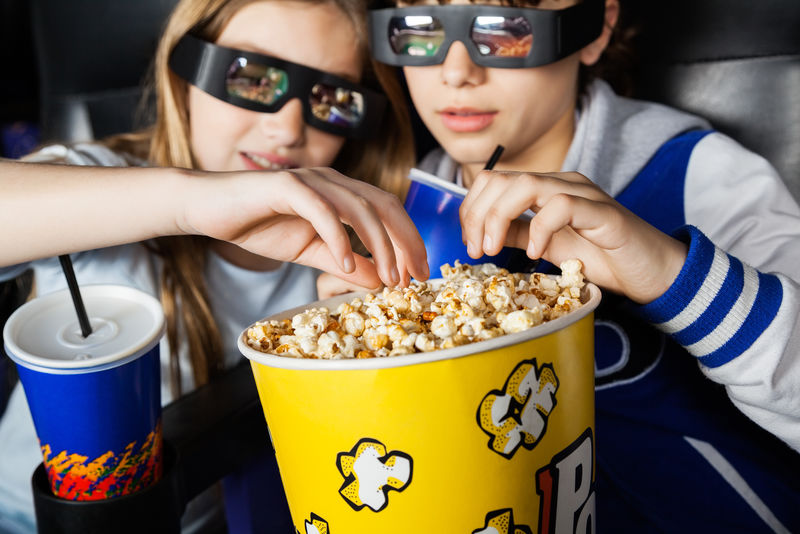 在电影院吃爆米花的戴3D眼镜的姐妹们