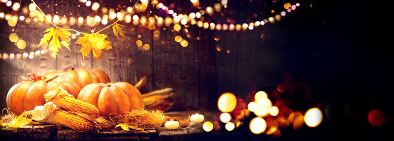 感恩节快乐的背景-木桌上装饰着南瓜-玉米芯-蜡烛和花环-万圣节前夕-美丽的节日秋日概念场景秋收