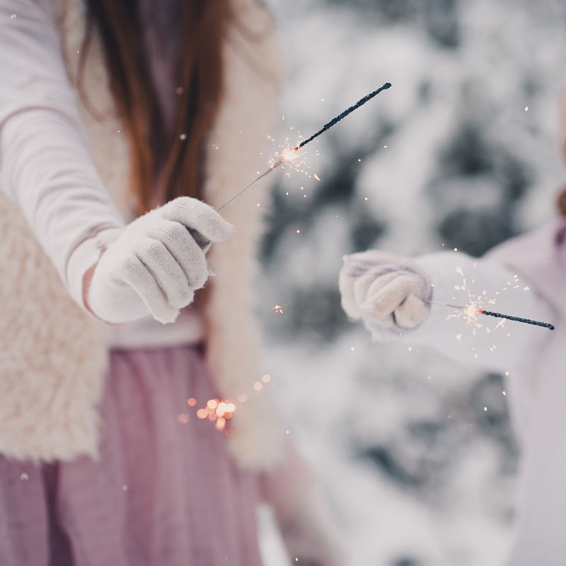 孩子们在户外玩火花枪。在雪地上穿着冬衣和手套。圣诞节假期。童年。