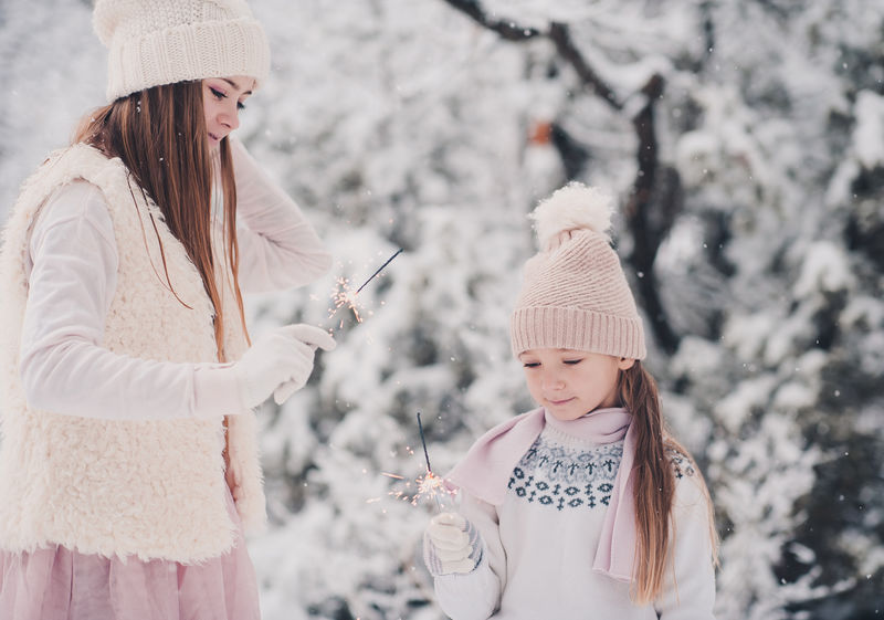 有趣的小女孩在户外的雪地上玩火花。冬季。幸福。