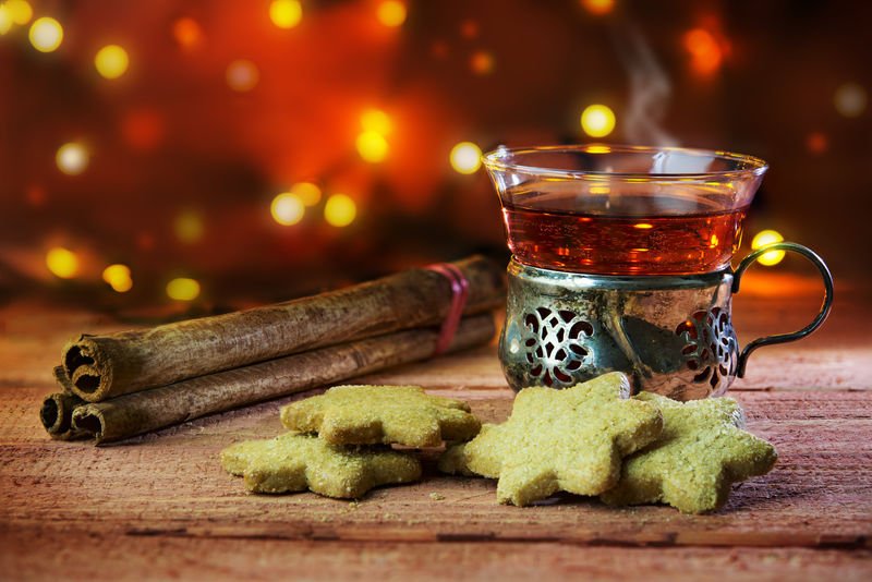 热茶或热葡萄酒，配圣诞曲奇和肉桂棒，放在一张乡村编织的桌子上