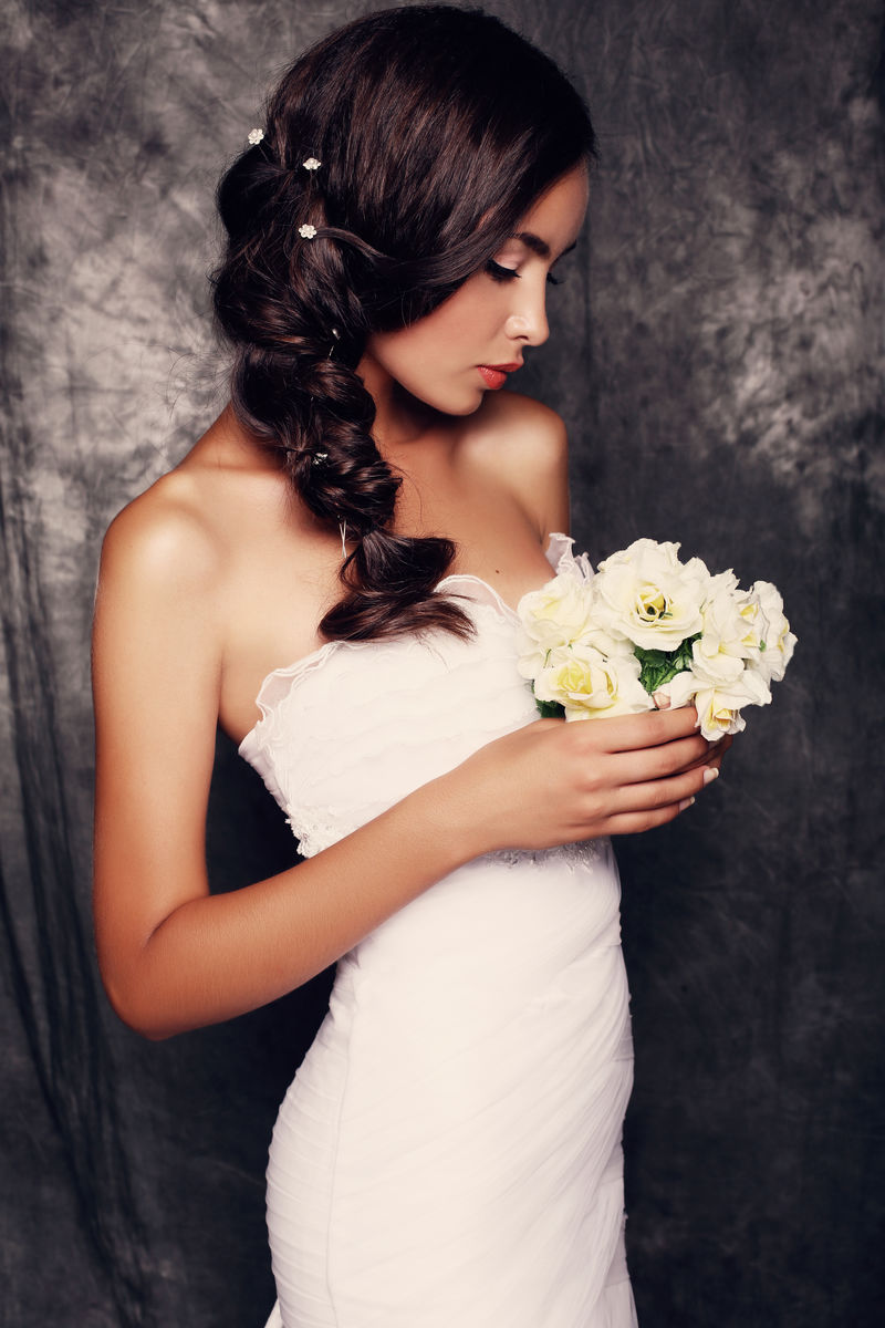 美丽的新娘，深色头发，穿着优雅的婚纱