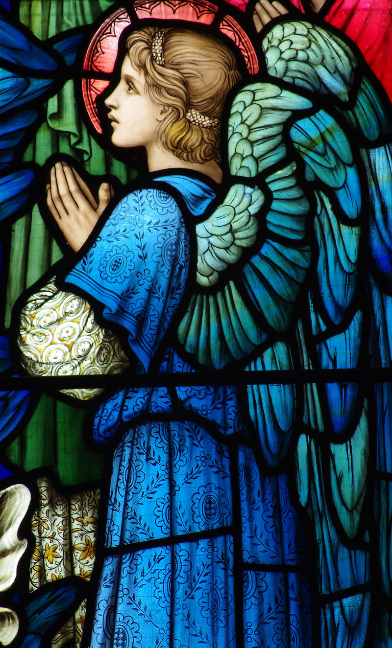 在彩色玻璃窗里祈祷的天使