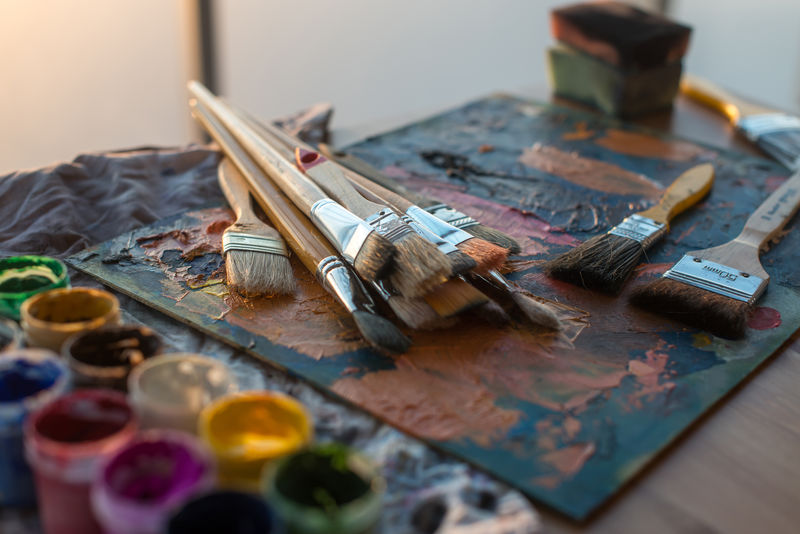 在艺术工作室中绘制类工具。画笔摆放在油彩画笔上。