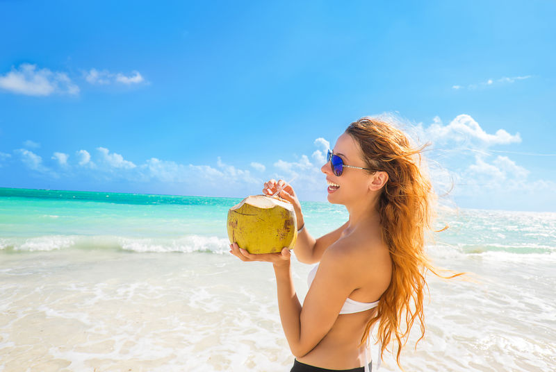 热带海滩上戴着太阳镜欣赏海景的女人