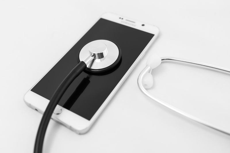 医用听诊器工具-位于移动智能手机表面-成分隔离在白色背景上