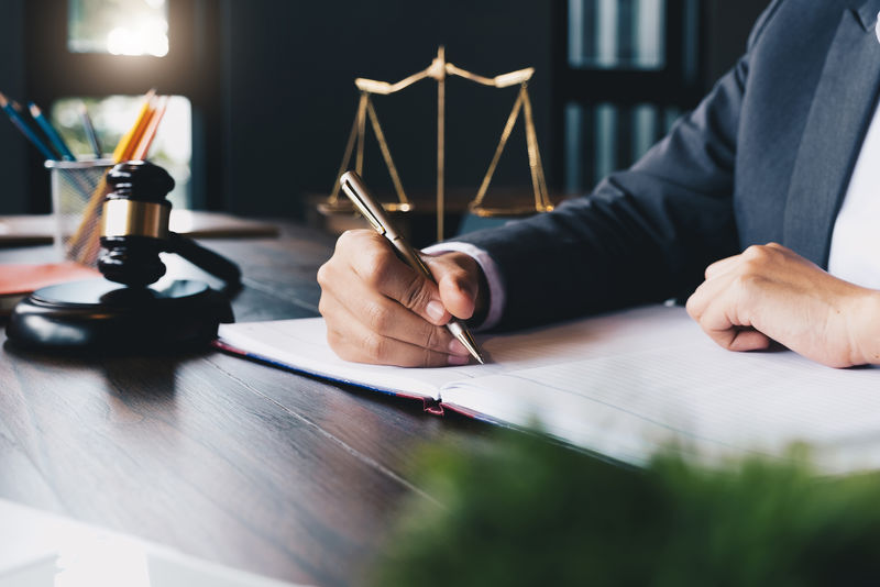 法官与司法律师、诉讼中的商业人士或处理文件的律师一起使用木槌-法律、咨询和司法理念