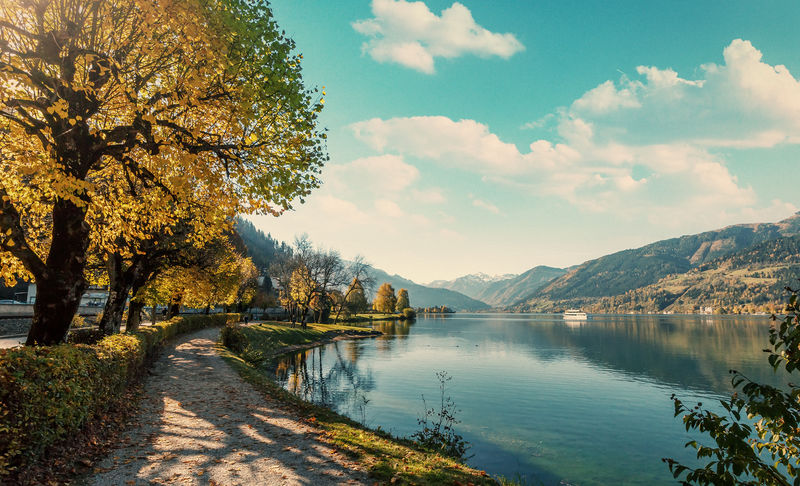 美丽的风景。阳光下迷人的秋景。五彩缤纷的公园附近的旅游小径，湖水清澈，天空壮观。理想休息场所的概念。泽尔湖。阿尔卑斯山，奥地利