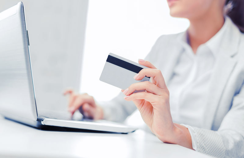 银行、购物、理财概念-带笔记本电脑和信用卡的女商人
