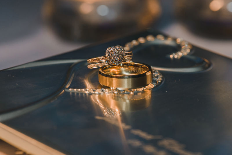 反光桌上镶有钻石的金心婚戒