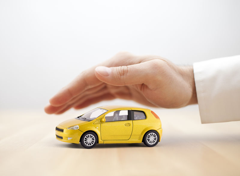 黄色汽车玩具手保车险概念