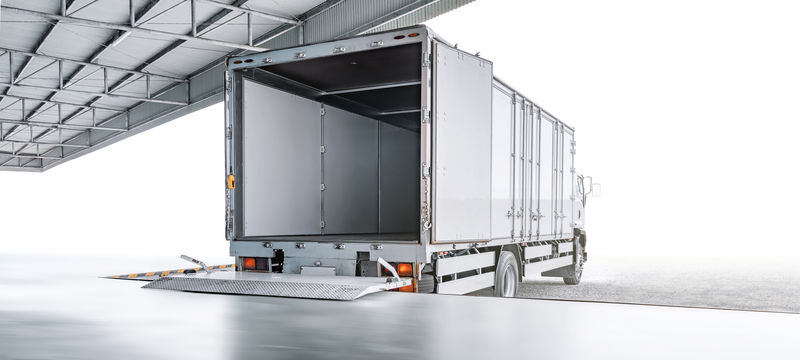 在工业仓库、运输或物流概念处等待装载出口商品的运输卡车