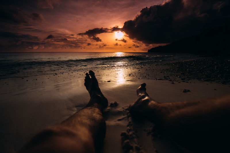 坐在沙滩上看日落的人