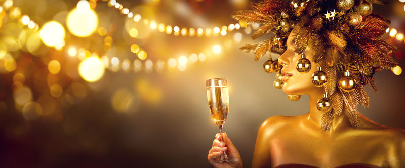 美丽迷人的金色圣诞女人用香槟庆祝-戴着用装饰品装饰的花环-派对上-喝着起泡酒-节日的背景光彩夺目-圣诞节-新年假期庆祝