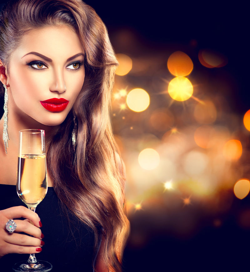 性感的模特女郎-在派对上喝着香槟-在节日的背景下喝着香槟-拥有完美时尚妆容的美女-圣诞节和新年庆祝活动