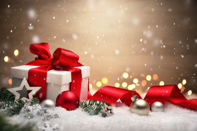 带白色礼品盒、红色蝴蝶结和缎带、灯光、装饰品、冷杉枝和雪的圣诞场景-带复印空间