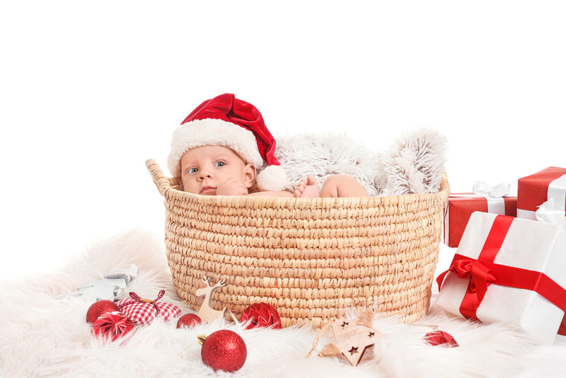 快乐微笑的宝宝趴在肚子上-戴着一顶红白相间的圣诞老人帽和套装-被隔离在白色背景下