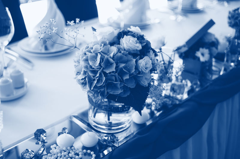 时尚经典的蓝色漂亮花束装饰在一家餐厅的结婚桌上。2020年颜色