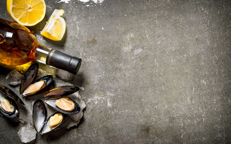 蛤蜊配葡萄酒和柠檬。在石桌上。